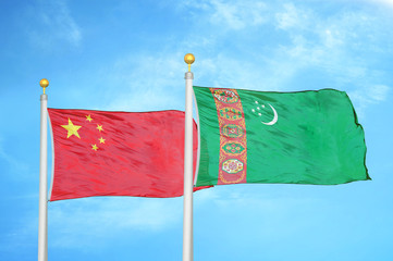China and Turkmenistan two flags on flagpoles and blue cloudy sky
