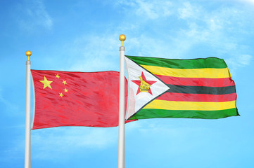 China and Zimbabwe two flags on flagpoles and blue cloudy sky