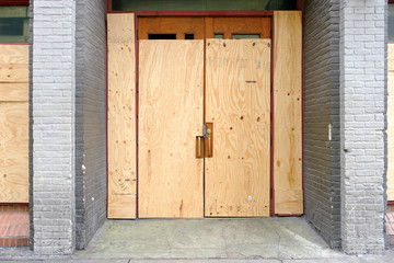 Closed or failed business location with boarded up front doors. Concept of economic crisis with many closed restaurants due to coronavirus.