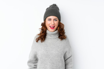 Young Russian woman with winter hat over isolated white background with surprise facial expression