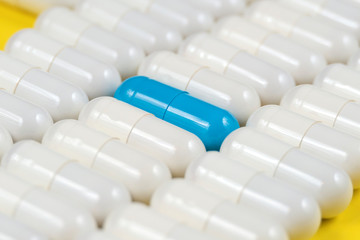 one blue pill among white pills