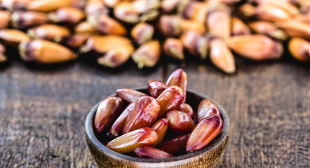 many pine nut seeds in rustic wooden bowl. Typical Brazilian food during the winter.