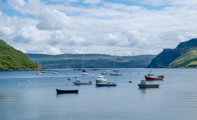 Portree harbor with small boats staying at anchors, Island of Skye, Hebrides archipelago, Scotland.