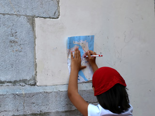 Little girl with red scarf on her head marking the itinerary of a trip on a map