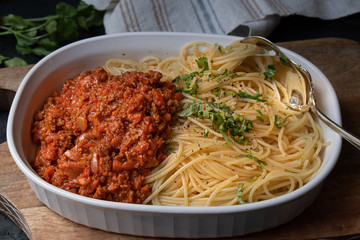 Vegan  seitan spaghetti bolognese in white serving dish
