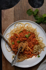 Vegan spaghetti and seitan bolognaise on white plate