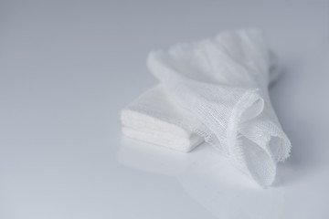 White medical cotton gauze bandage on white, gray background, Medical bandage of new first aid gauze unrolling