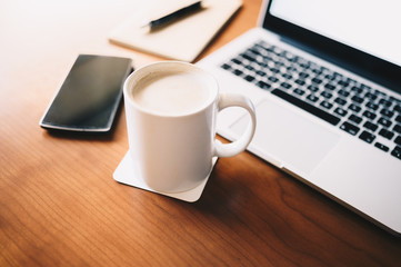 Classic workplace with a cup of coffee laptop and notebook.Business,workplace and technology concept.