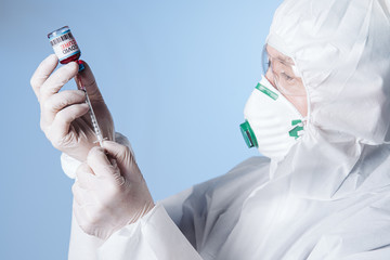 The medic gets the vaccine into the syringe. Glass medical bottle in a doctor's hand. A bottle with...