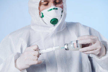 The doctor gets the cure into the syringe. Glass medical bottle in a doctor's hand. A bottle with a...