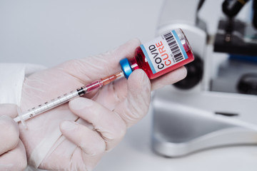 The medic gets the vaccine into the syringe. Glass medical bottle in a doctor's hand. A bottle with...