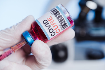 The medic gets the vaccine into the syringe. Glass medical bottle in a doctor's hand. A bottle with...