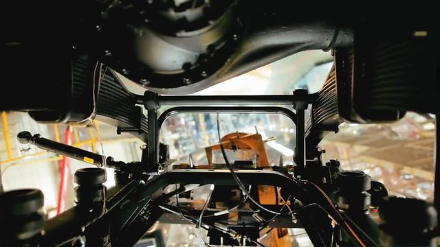 Close up of the process of car assembly at the production line. Stock footage. Rotating detail of the mechanism at the car assembly factory, construction concept.