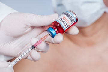 Glass medical bottle in a doctor's hand. A bottle with a cure holds a hand in silicone gloves in a...