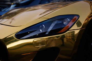 A golden car, a golden car on the street, a luxury car.