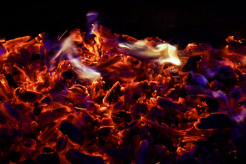 Burning firewood in the fireplace close up, BBQ fire, charcoal background. Charcoal fire with sparks