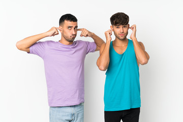 Two men over isolated background covering both ears with hands