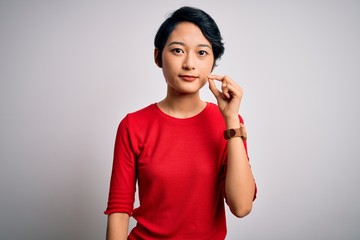 Young beautiful asian girl wearing casual red t-shirt standing over isolated white background mouth...