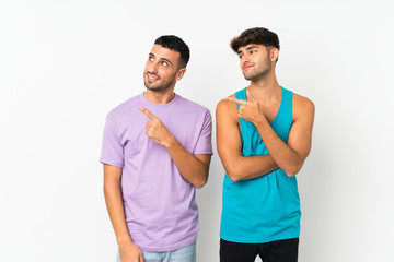 Fototapeta premium Two men over isolated background pointing to the side to present a product
