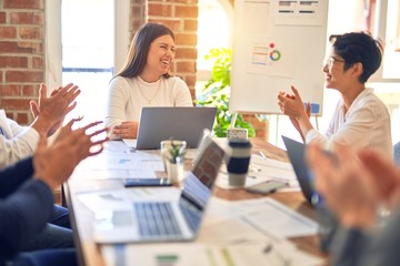 Group of business workers smiling happy and confident. Working together with smile on face applauding one of them at the office