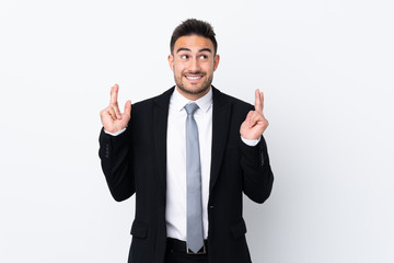 Young business man over isolated background with fingers crossing