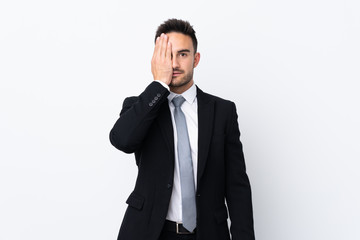 Young business man over isolated background covering a eye by hand