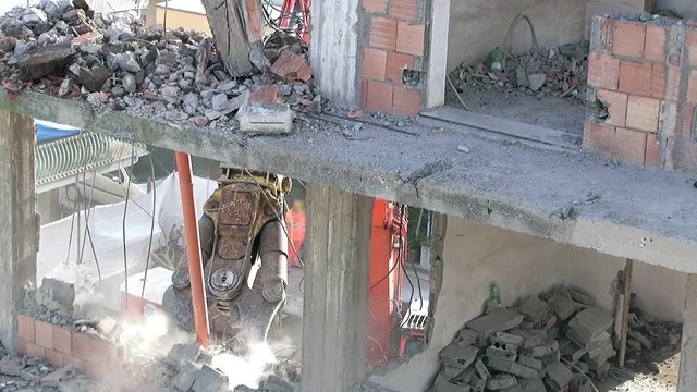 A rotational grapple demolishing a small edifice