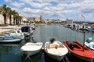 Obraz premium Small colorful fishing boats in the port of Split, Croatia. Traditional Mediterranean architecture with landmark Saint Domnius tower in the background. 