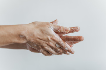 Fototapeta premium Detalhe de mãos femininas com espuma de sabonete. Lavar as mãos para combater o coronavírus.