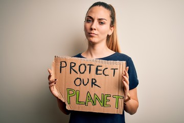 Fototapeta na wymiar Young beautiful blonde woman with blue eyes asking for protect planet holding banner with a confident expression on smart face thinking serious