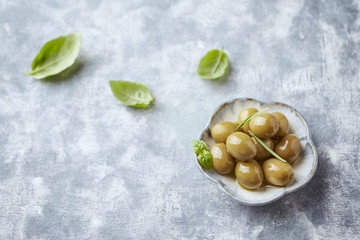 Green olives on bright wooden background. Close up. 