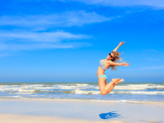 young woman jumping on the beach