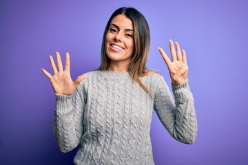 Young beautiful woman wearing casual sweater standing over isolated purple background showing and...