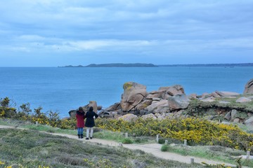 People walking on the path of the pink granite coast in Brittany. France