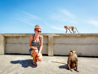 Young tourist woman and monkey