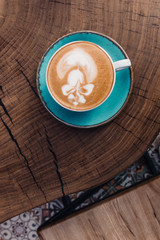 Soft focus on latte coffee cup. Hot milk art coffee on wooden table in cafe.