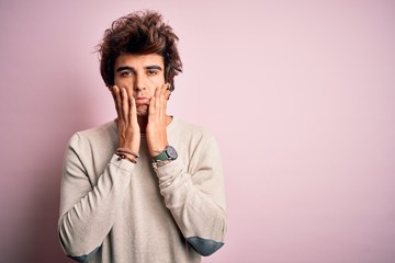 Fototapeta na wymiar Young handsome man wearing casual t-shirt standing over isolated pink background Tired hands covering face, depression and sadness, upset and irritated for problem