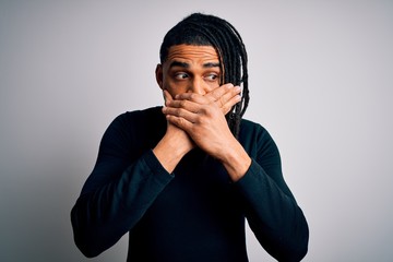 Young handsome african american man with dreadlocks wearing black casual sweater shocked covering mouth with hands for mistake. Secret concept.