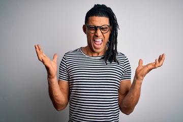 Young handsome african american man with dreadlocks wearing striped t-shirt and glasses celebrating...