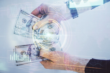 Multi exposure of technology drawing hologram and us dollars bills and man hands. Data concept