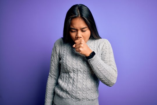 Young beautiful asian girl wearing casual sweater standing over isolated purple background feeling unwell and coughing as symptom for cold or bronchitis. Health care concept.