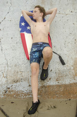 Young teen at beach reclining with boogie board