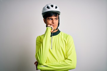 Young handsome cyclist man wearing security bike helmet over isolated white background with hand on chin thinking about question, pensive expression. Smiling with thoughtful face. Doubt concept.