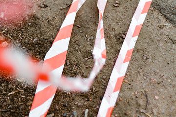 Torn red security tape with white stripes, close-up, meet visitors and blocks the entrance to the...