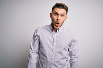 Young business man with blue eyes standing over isolated background afraid and shocked with surprise expression, fear and excited face.