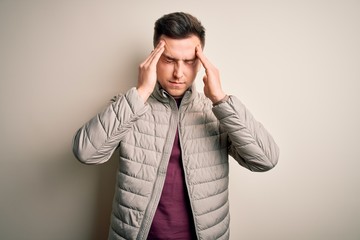 Young handsome caucasian man wearing casual winter jacket standing over isolated background suffering from headache desperate and stressed because pain and migraine. Hands on head.