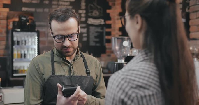 Woman with credit card buying coffee at cafe or coffee shop