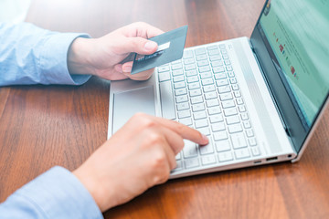 Consumer shopping online with credit card in hand