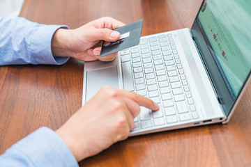 Consumer shopping online with credit card in hand