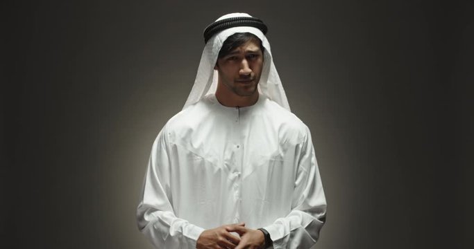 Bearded angry arab man looking at camera and crossing his arms in "no" gesture, isolated on black background close up shot 4k